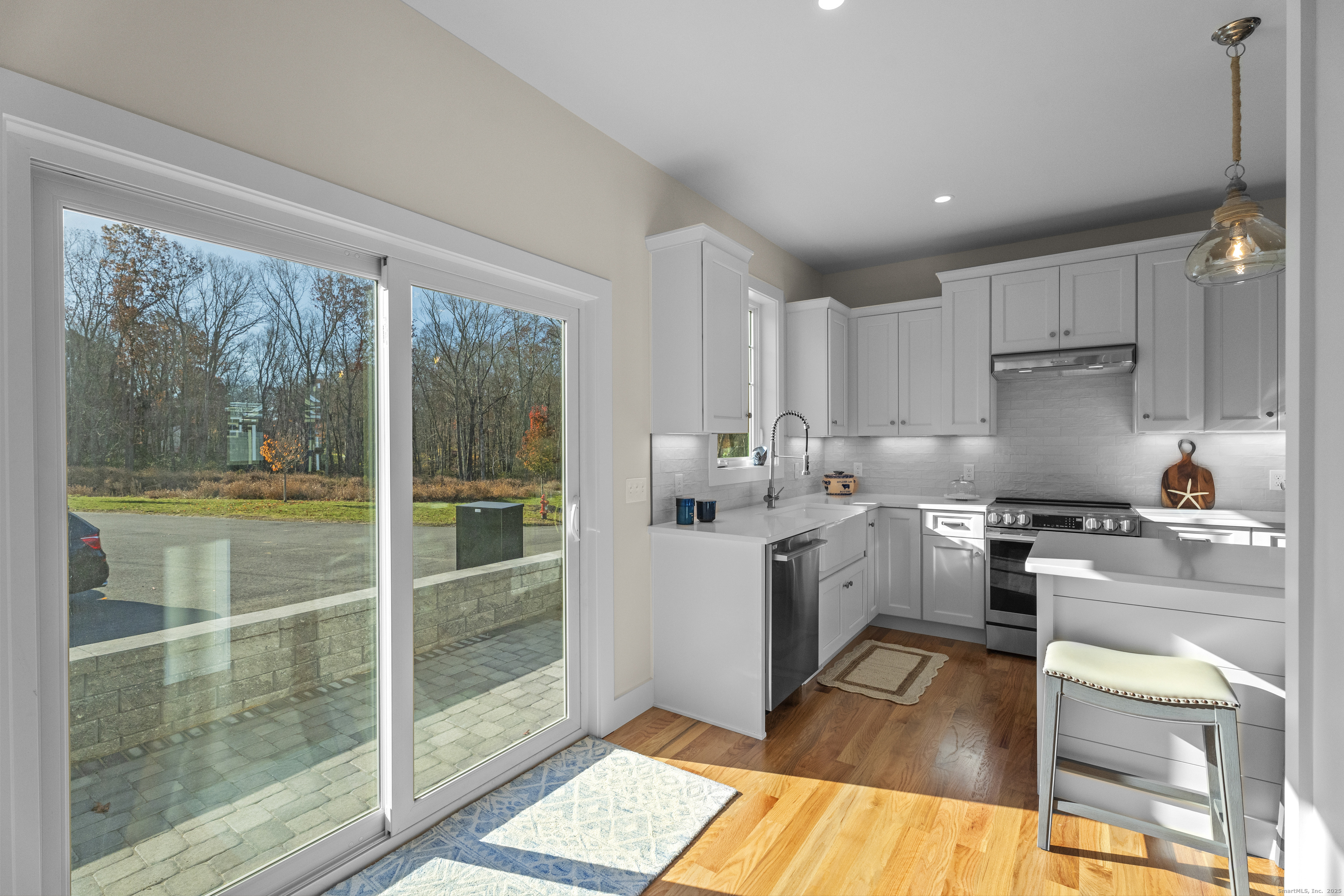 7 Ivy Hill Road, Unit 7 Waterford, CT 06385 - Photo 12 of 35 a kitchen with a stove a refrigerator and white cabinets with wooden floor