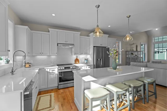 a kitchen with stainless steel appliances granite countertop a stove a sink a refrigerator a center island and a stove