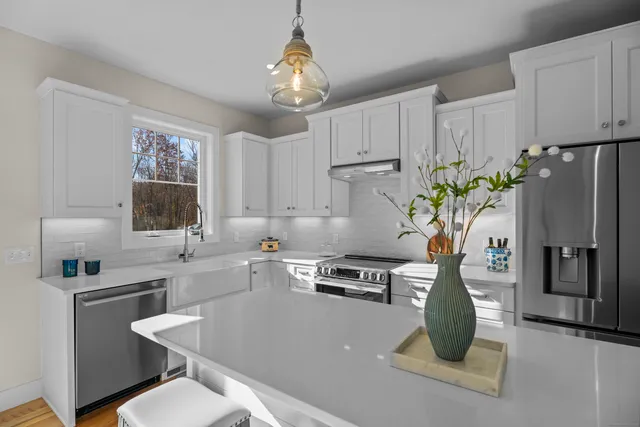 a kitchen with stainless steel appliances a sink a table and chairs