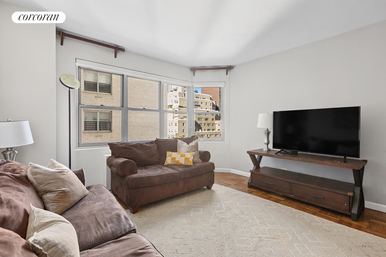 400 East 56th Street, Unit 17F Manhattan, NY 10022 - Photo 2 of 9 a living room with furniture and a flat screen tv