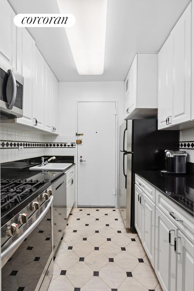 400 East 56th Street, Unit 17F Manhattan, NY 10022 - Photo 6 of 9 a kitchen with granite countertop a refrigerator stove and sink