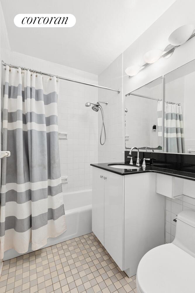 400 East 56th Street, Unit 17F Manhattan, NY 10022 - Photo 7 of 9 a bathroom with a sink toilet and shower