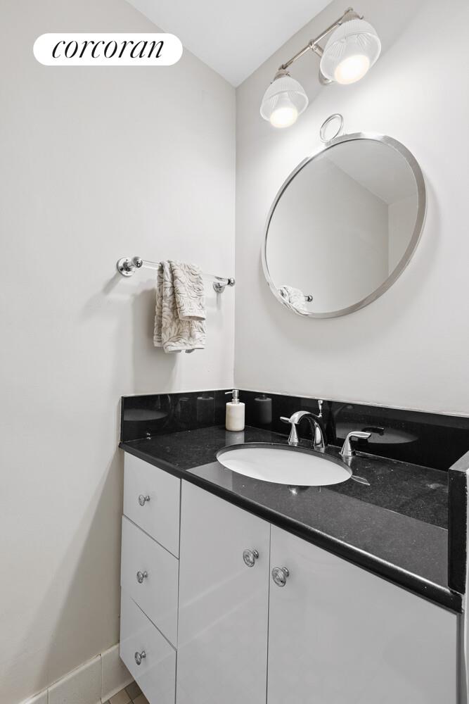 400 East 56th Street, Unit 17F Manhattan, NY 10022 - Photo 8 of 9 a bathroom with a granite countertop sink a mirror and shower