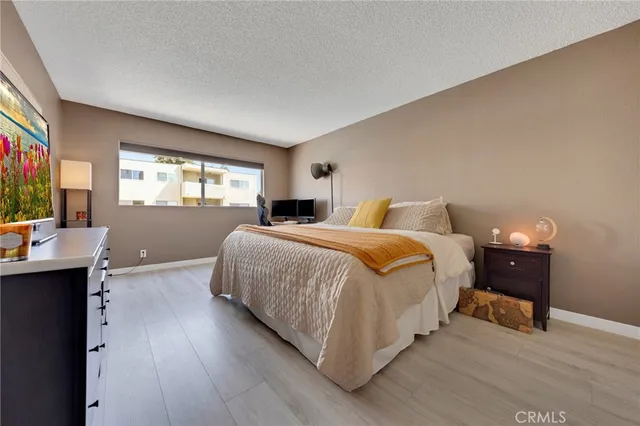 a bedroom with a bed and wooden floor