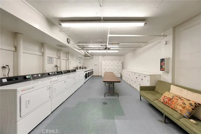 a large white kitchen with a stove a sink dishwasher and cabinets with wooden floor