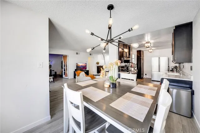 a kitchen with a dining table chairs stainless steel appliances and cabinets
