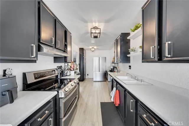 a kitchen with stainless steel appliances granite countertop a sink stove and cabinets