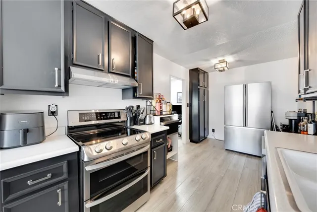 a kitchen with stainless steel appliances a stove a sink and a refrigerator