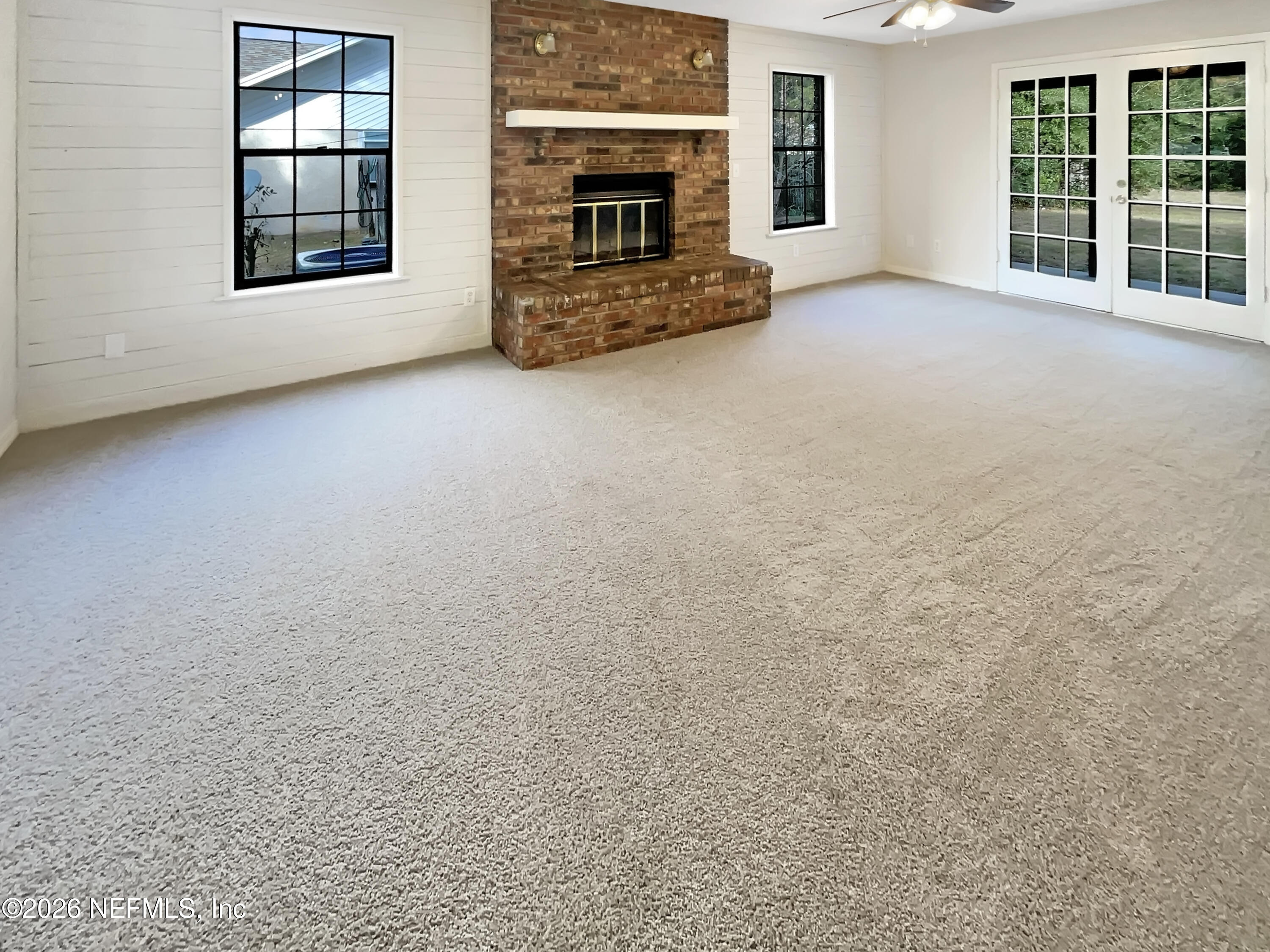 1555 Dolph Road Jacksonville, FL 32220 - Photo 3 of 21 an empty room with floor to ceiling window and fireplace