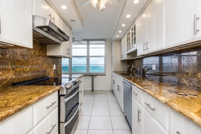 a kitchen with granite countertop white cabinets and appliances