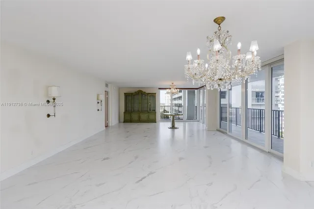 a view of a livingroom with a chandelier furniture and windows