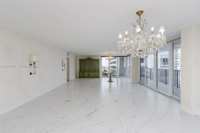 a view of a livingroom with a chandelier furniture and windows