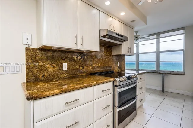 a kitchen with stainless steel appliances granite countertop a sink and a refrigerator