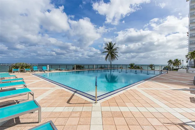 a living room with furniture a chandelier and a rug