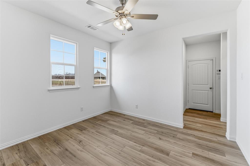 144 Oak Grv Way Springtown, TX 76082 - Photo 11 of 27 a view of an empty room with wooden floor and a window
