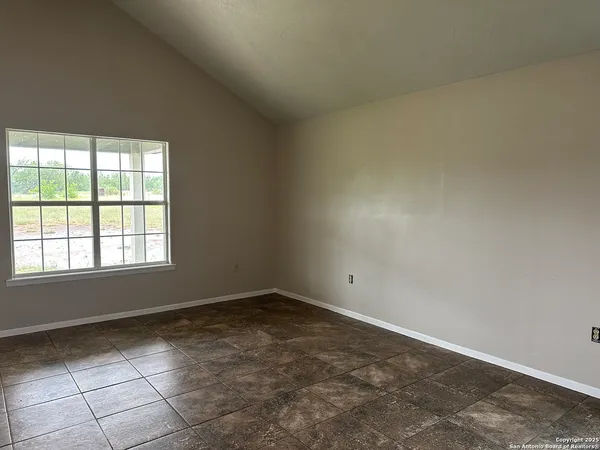 an empty room with fan and windows