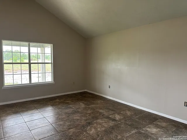 an empty room with fan and windows