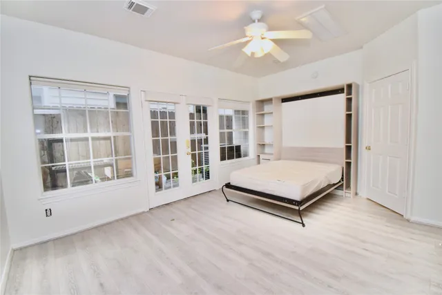 a bedroom with a bed and a large window with garden view