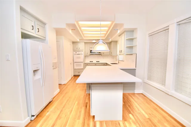 a kitchen with kitchen island a sink cabinets and wooden floor