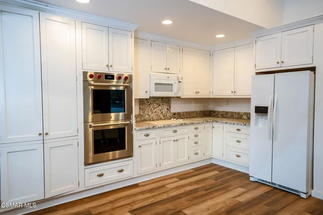 a kitchen with a table chairs sink and cabinets