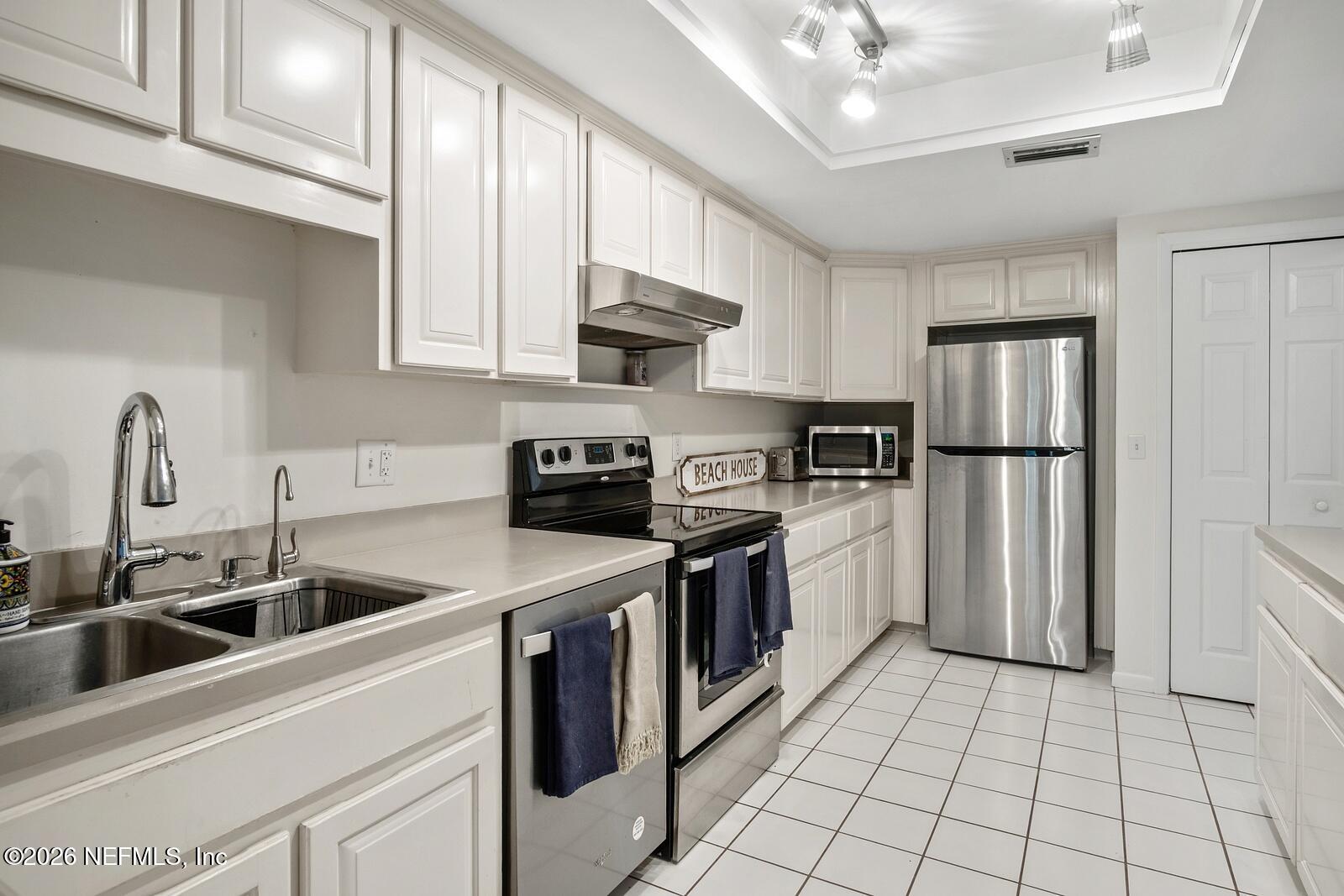 8012 Hollyridge Road, Unit 17U Jacksonville, FL 32256 - Photo 5 of 22 a kitchen with a sink cabinets and stainless steel appliances