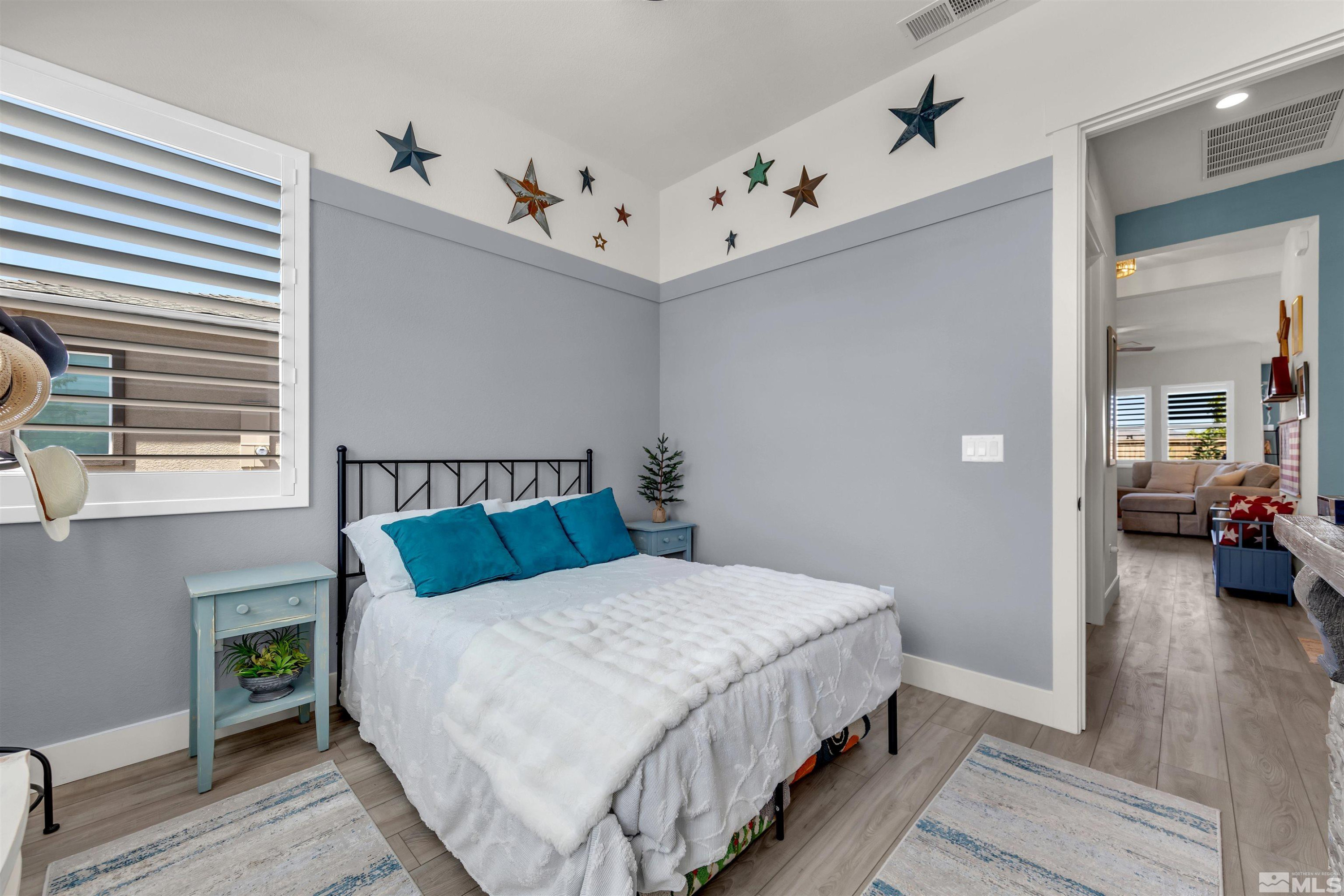 7341 Rustic Sky Drive Sparks, NV 89436 - Photo 13 of 40 a bedroom with a bed and a wooden floor