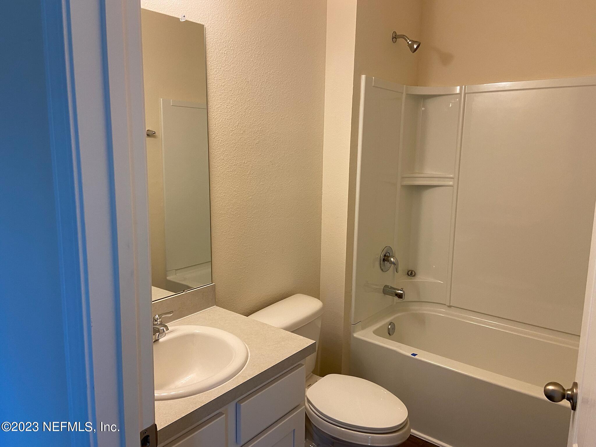 276 Falcon Ridge Road St. Augustine, FL 32084 - Photo 11 of 32 a bathroom with a granite countertop toilet a sink and bathtub