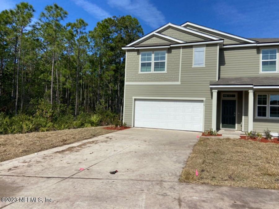 276 Falcon Ridge Road St. Augustine, FL 32084 - Photo 4 of 32 a front view of a house with a yard and garage