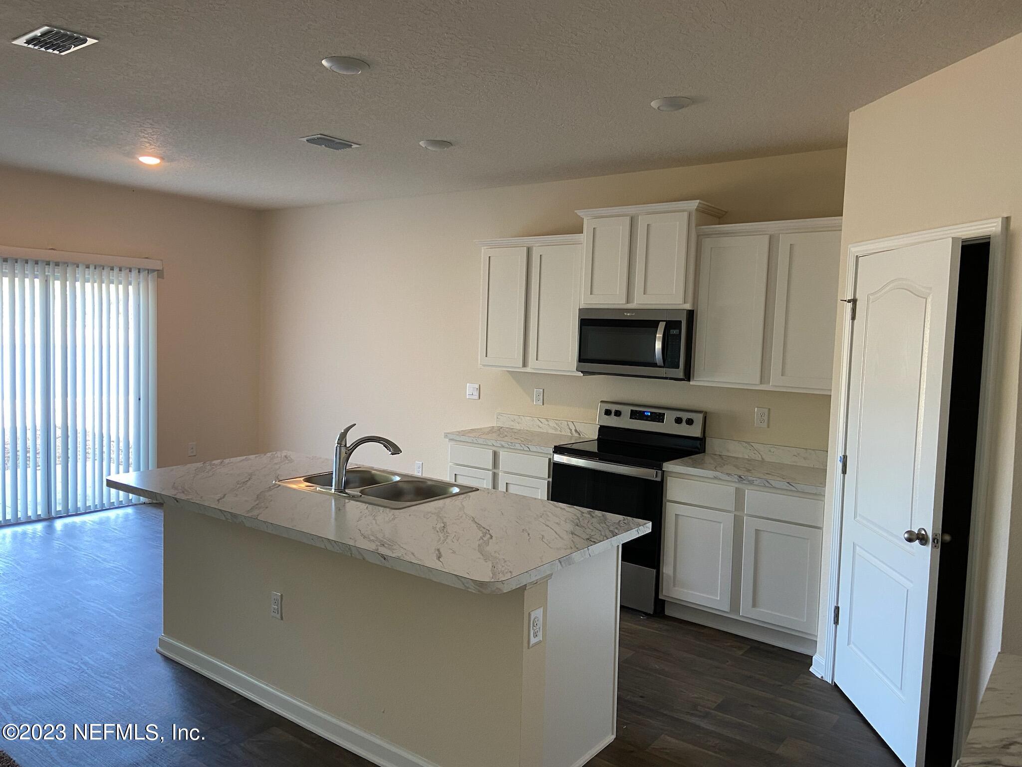 276 Falcon Ridge Road St. Augustine, FL 32084 - Photo 6 of 32 a kitchen with granite countertop a sink stove and refrigerator