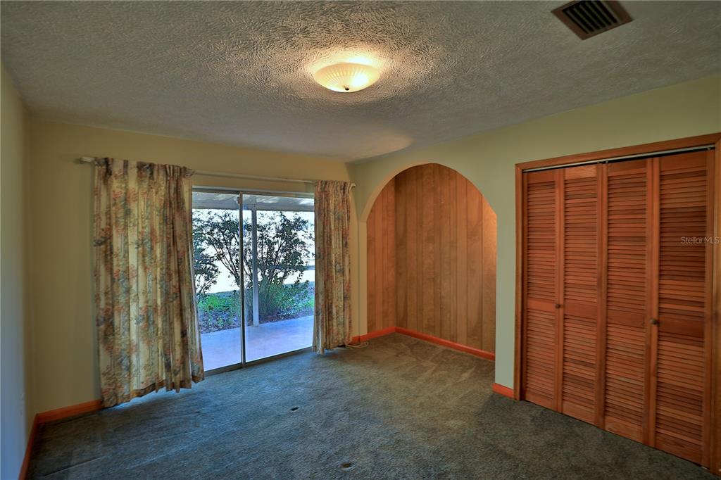 2155 Southeast County Highway 484 Belleview, FL 34420 - Photo 13 of 41 an empty room with sliding door and wooden floor