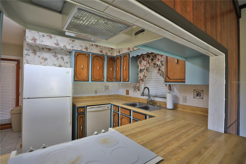 2155 Southeast County Highway 484 Belleview, FL 34420 - Photo 14 of 41 a kitchen with stainless steel appliances a refrigerator a sink a stove and white cabinets