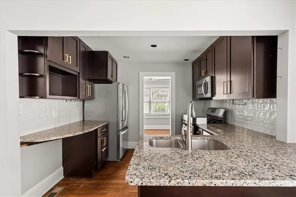 a kitchen with stainless steel appliances granite countertop a sink stove and refrigerator
