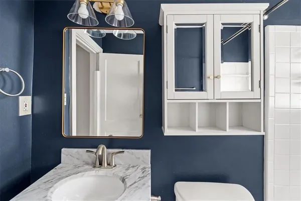 a bathroom with a toilet sink and mirror