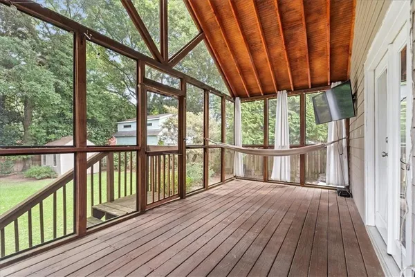 a view of a wooden deck with large trees