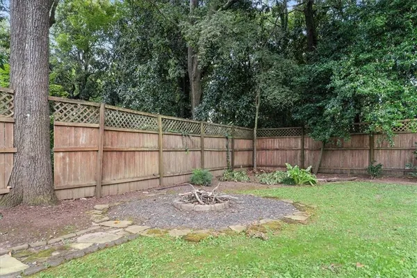 a view of a yard in front of a house with large trees