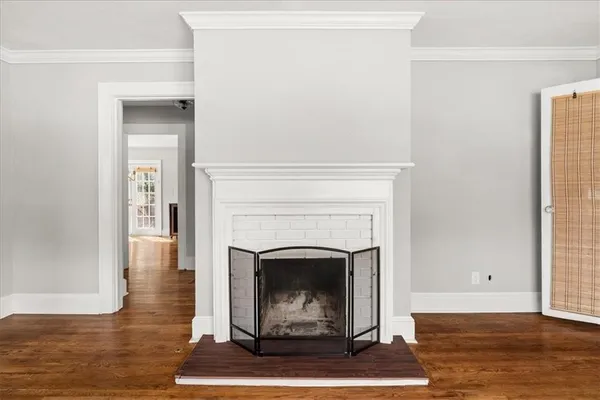 a living room with a fireplace and wooden floor
