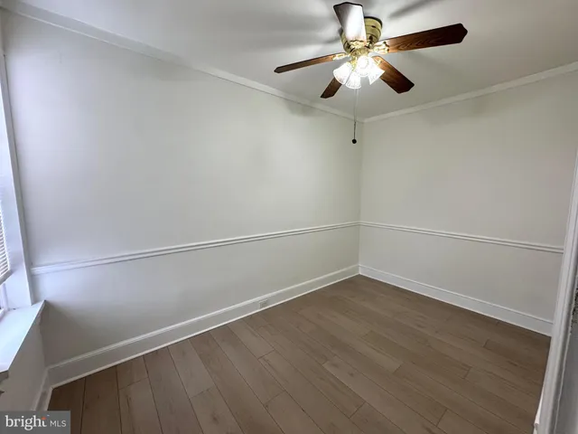 a view of a room with wooden floor and fan