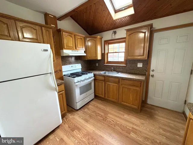 a kitchen with a sink cabinets stainless steel appliances and a window