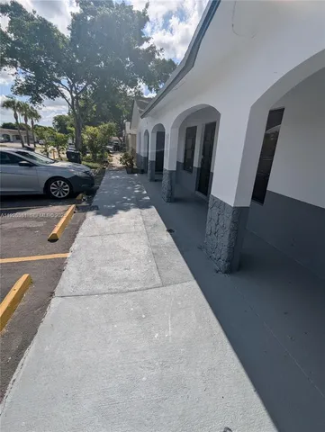 a view of a building with cars parked