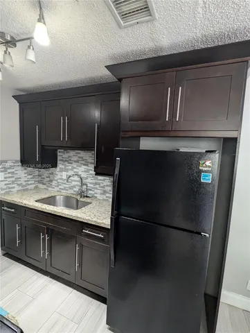 a kitchen with a refrigerator and a sink