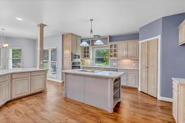 a kitchen with stainless steel appliances granite countertop wooden floors and white cabinets