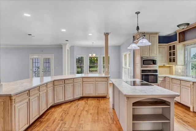 a large kitchen with stainless steel appliances granite countertop a stove and a wooden floors