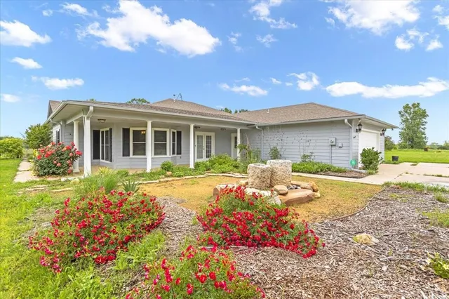 a front view of house with yard and trees around