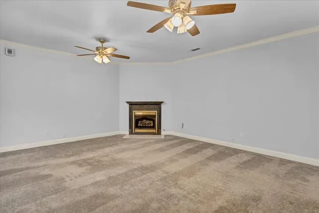 an empty room with a fan and a chandelier fan