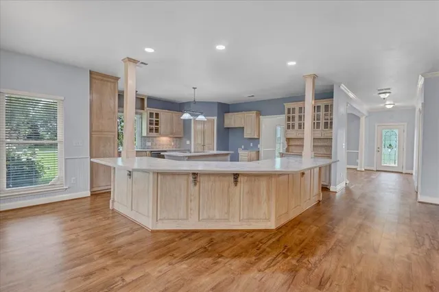 a large kitchen with stainless steel appliances kitchen island a large counter top and a wooden floors