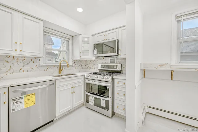 a kitchen with cabinets stainless steel appliances and a window