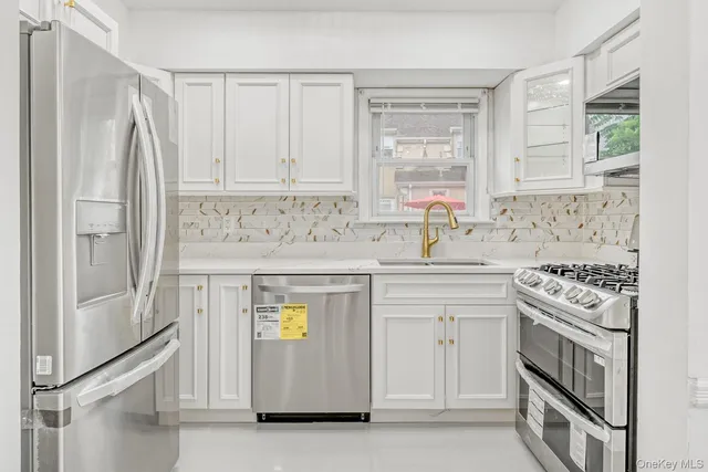 a kitchen with stainless steel appliances granite countertop a stove a sink and a refrigerator