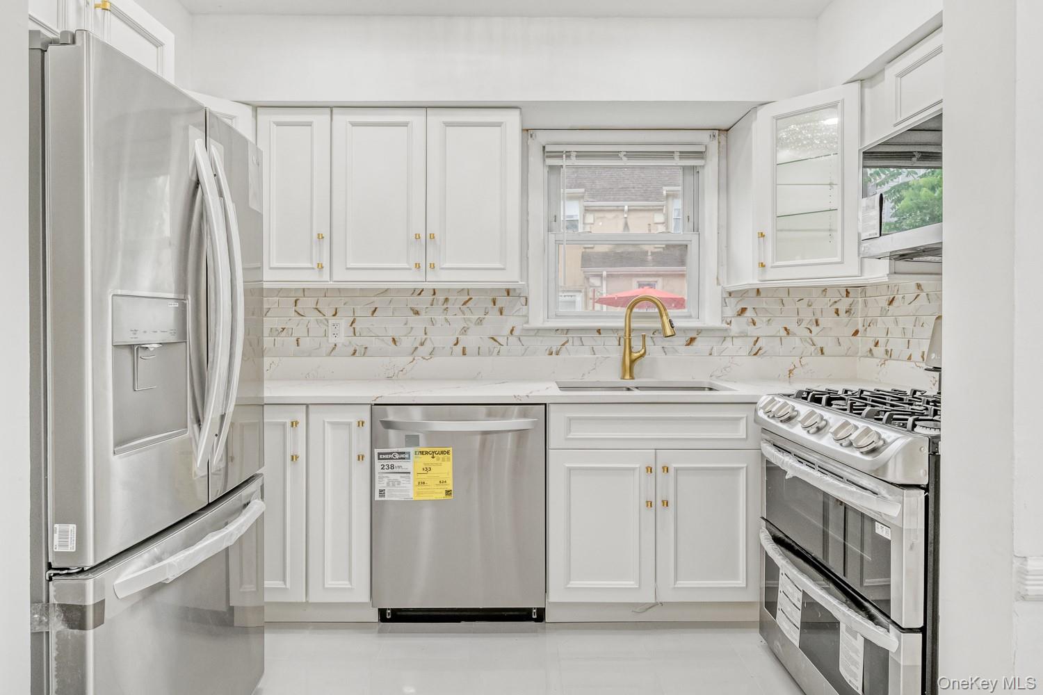 37 Keystone Place Hewlett, NY 11557 - Photo 15 of 45 a kitchen with stainless steel appliances granite countertop a stove a sink and a refrigerator