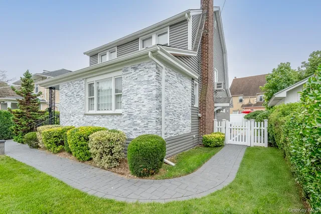 a view of a house with brick walls and a yard with plants