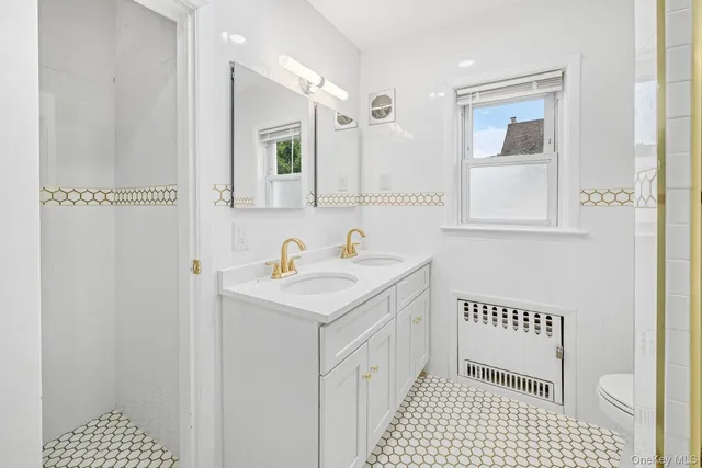 a bathroom with a sink a toilet and a mirror